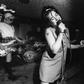 Kathleen Hanna (right) singing live with Bikini Kill in the early '90s